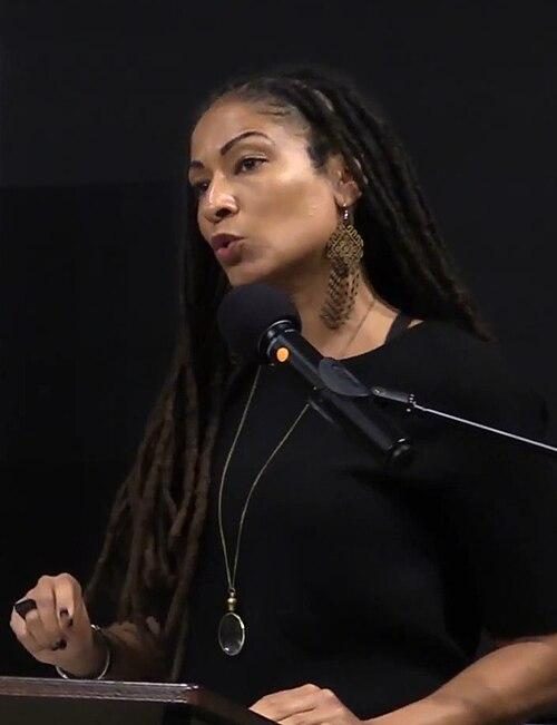 Ruha Benjamin speaking at a podium.