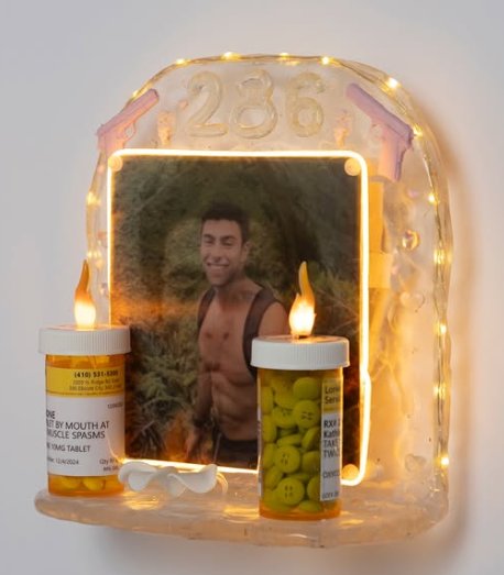 A resin shrine-like piece with fairy lights, tea light candles and a portrait mounted inside a resin arch.