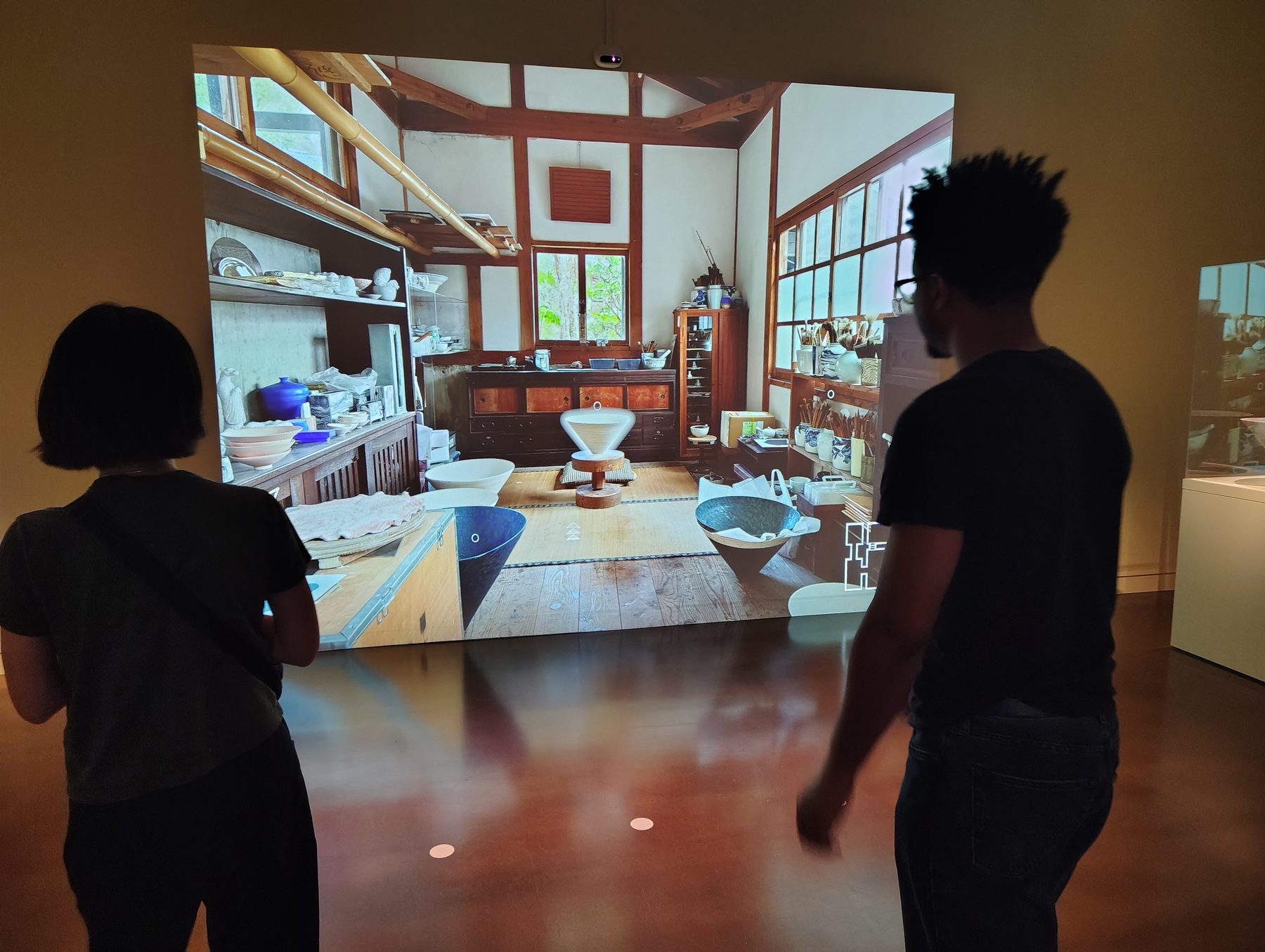 Visitors exploring the projected interactive experience of Takahiro's studio
