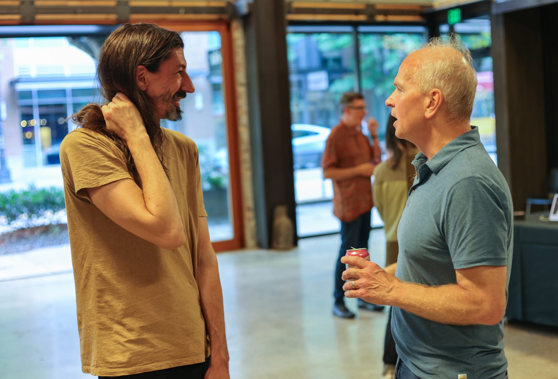 Two visitors in conversation near the front doors, xispa's storefront visible behind them.